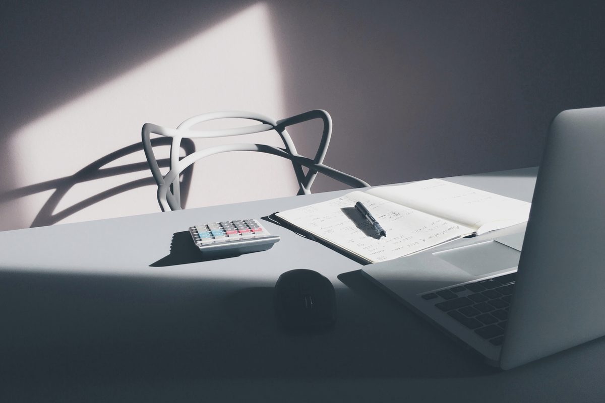 A desk with laptop and calculator ready for bookkeeping work