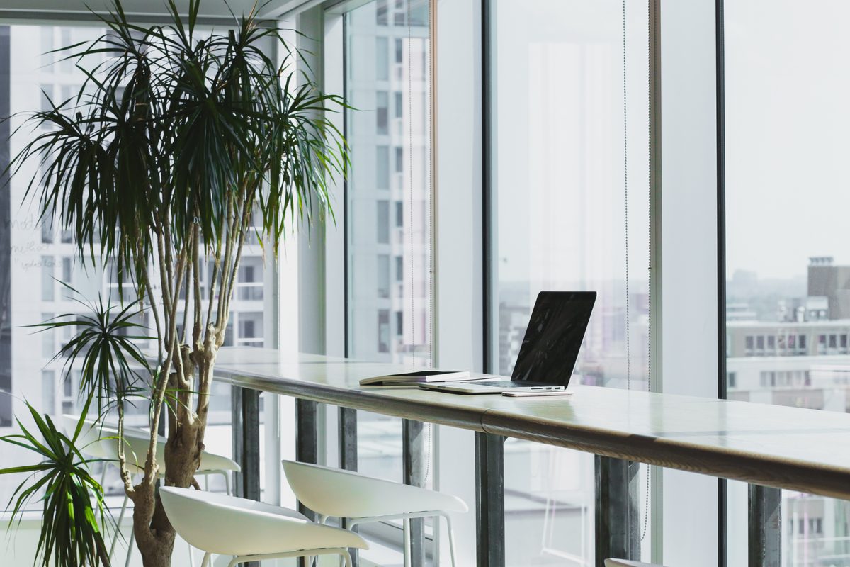 A modern office workspace with laptops on a shared desk