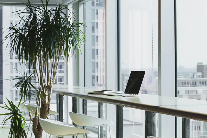 A modern office workspace with laptops on a shared desk