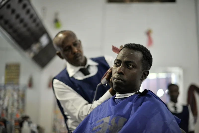 A barber giving a client a haircut in a barber shop