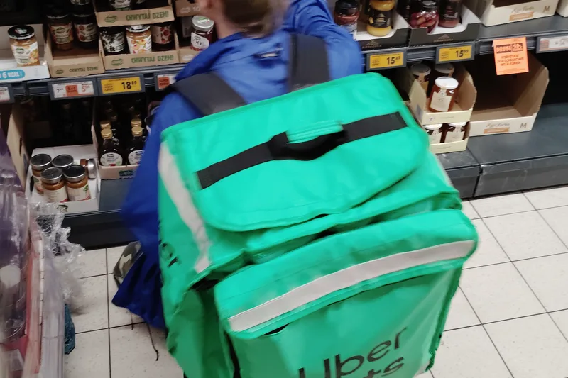A food delivery courier working with an insulated delivery bag