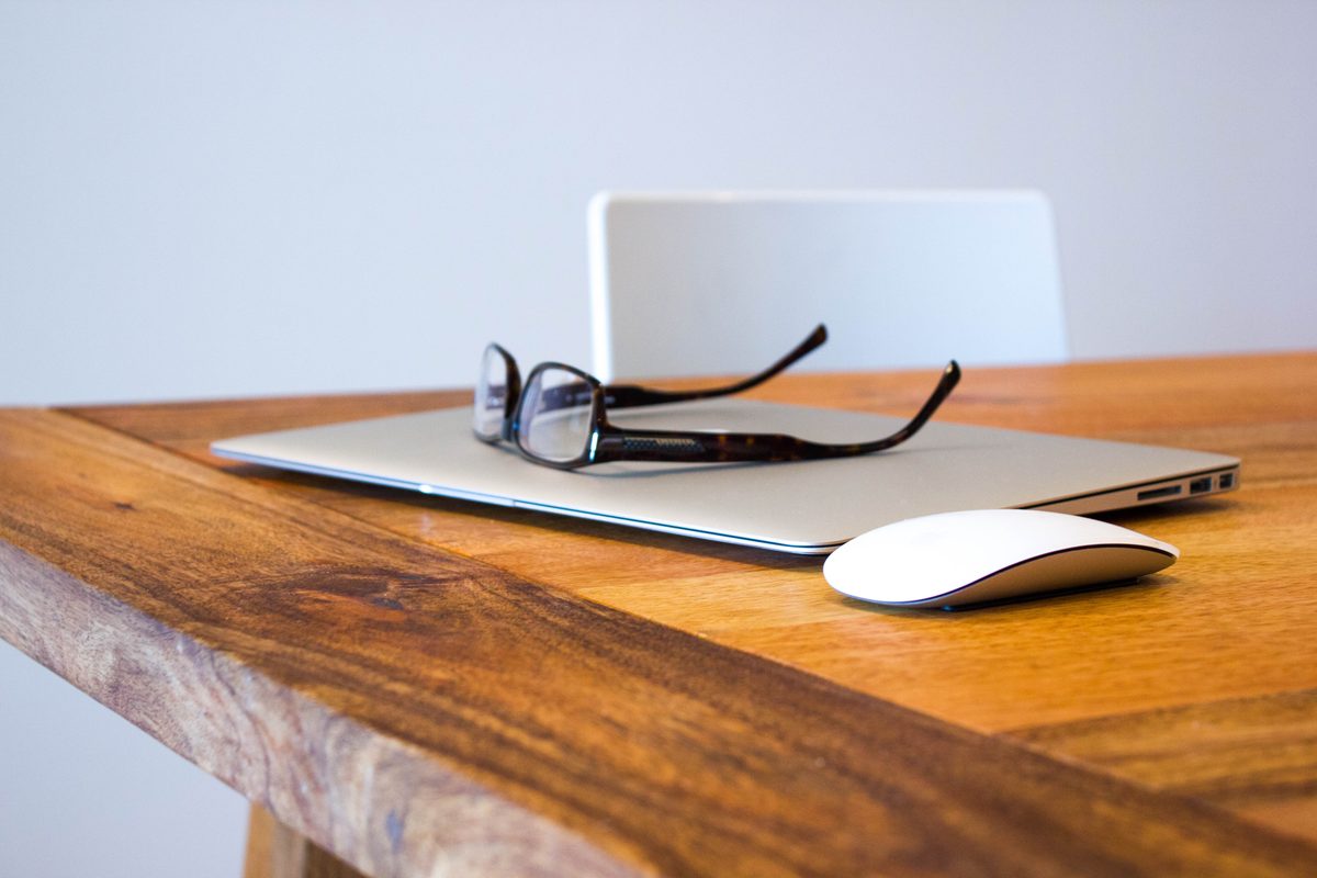 A developer workspace with laptop, monitor, and notebook on a desk
